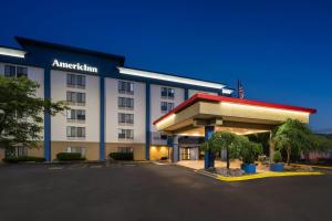 a hotel with an americanan sign in a parking lot at AmericInn by Wyndham Madison West in Madison