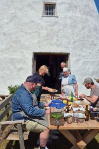 a group of people sitting around a table with food at Partsi Veski in Partsi