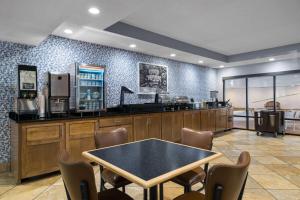 a restaurant with a table and chairs in a room at AmericInn by Wyndham Madison West in Madison