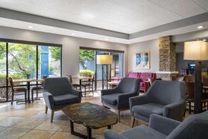 a waiting room with chairs and tables and windows at AmericInn by Wyndham Madison West in Madison
