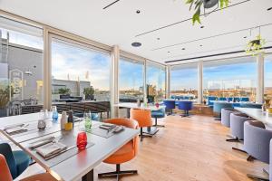 a restaurant with tables and chairs and large windows at b'mine Duesseldorf, WorldHotels Crafted in Düsseldorf