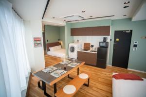 a room with a table and a kitchen and a bed at ORI Ikebukuro in Tokyo