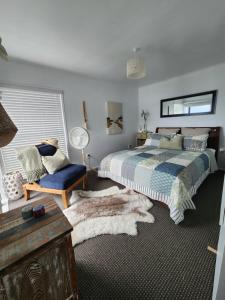 a bedroom with a bed and a chair at Darlene's Nest in Cable Bay