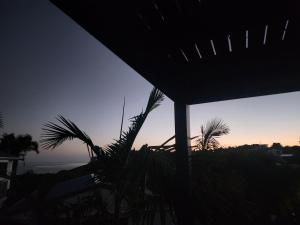a view of the sunset from a house with a plant at Darlene's Nest in Cable Bay