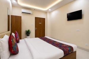 a bedroom with a white bed and a television at Hotel Philips in Kolkata