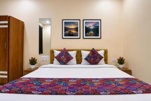 a bedroom with a large bed and two pictures on the wall at Hotel Philips in Kolkata