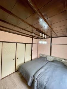 a bedroom with a bed in the middle of it at サニーサイドホステル2号館 in Uji