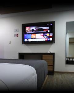 a bedroom with a flat screen tv on the wall at Hotel y Villas V Edén Atlacomulco in San Antonio Enchisi