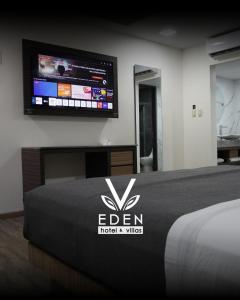 a bedroom with a bed with a tv on the wall at Hotel y Villas V Edén Atlacomulco in San Antonio Enchisi