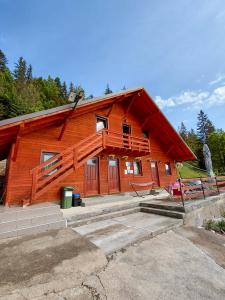 a log cabin with a porch and a balcony at Cabanutele Geo in Lacu Rosu