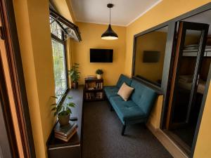 a living room with a blue couch and a window at Joy Fergana Guesthouse in Fergana
