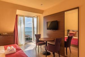 a hotel room with a table and a bed and a window at Tópart Hotel in Balatonvilágos