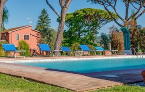 a pool with blue lounge chairs next to a house at Awesome Apartment In Roccastrada in Roccastrada +11 photos
