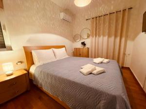 a bedroom with a bed with two towels on it at Elenas sweet home - Penthouse with Large Balcony in Pyrgos