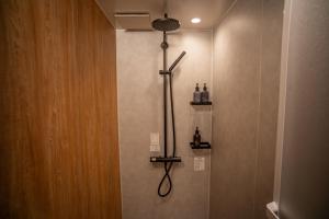 a shower in a bathroom with a cross on the wall at ORI Ikebukuro in Tokyo