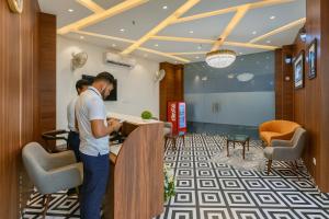 two men standing at a counter in a lobby at Hotel La Casa, Amritsar #swimming pool #prime location #luxury rooms #best selling hotel near golden temple in Amritsar +44 photos