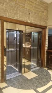 two glass elevators in a lobby with a brick wall at Hotel Rivoli in Mar del Plata