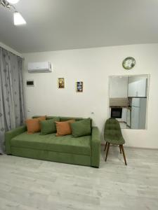 a green couch in a living room with a mirror at Green Home on Mtatsminda in Tbilisi City +21 photos