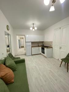 a living room with a green couch and a kitchen at Green Home on Mtatsminda in Tbilisi City