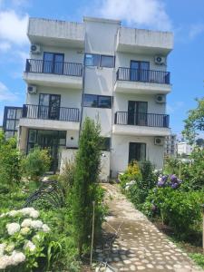 an apartment building with a garden in front of it at ilios in Kobuleti