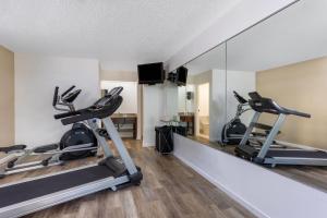 a gym with two treadmills and a mirror at Baymont by Wyndham Tallahassee in Tallahassee