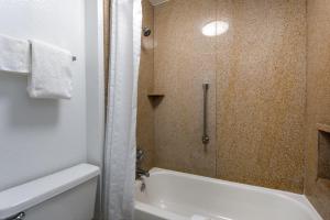 a bathroom with a shower and a bath tub at Baymont by Wyndham Tallahassee in Tallahassee