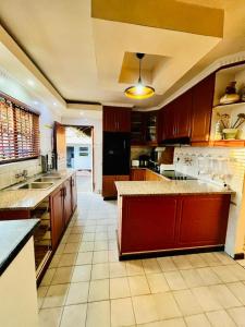 a large kitchen with wooden cabinets and a counter top at Emangwaneni Guest House in Kloof