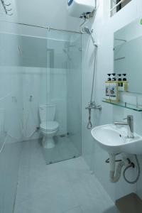 a white bathroom with a toilet and a sink at Dreams Boutique House in Hue City Center in Hue