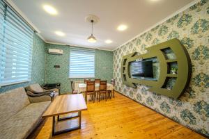 a living room with a couch and a tv on the wall at Gabala Garden Harmony in Gabala