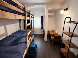 a room with two bunk beds and a desk at 出雲大社まで徒歩5分 一棟貸し宿 はれいろ in Izumo