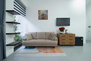 a living room with a couch and a tv at Dreams Boutique House in Hue City Center in Hue
