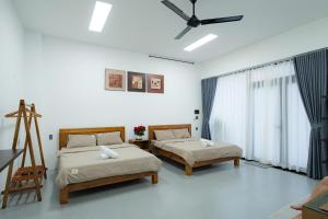 a bedroom with two beds and a ceiling fan at Dreams Boutique House in Hue City Center in Hue