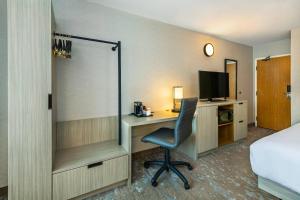 a hotel room with a desk with a chair and a television at Comfort Inn Saskatoon Centre in Saskatoon +46 photos