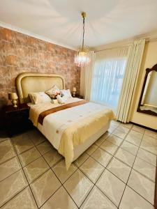 a bedroom with a bed and a brick wall at Emangwaneni Guest House in Kloof
