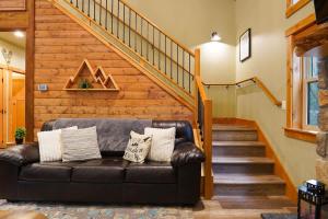 a leather couch in a living room with a staircase at Cottonwood Cabin in Glacier +42 photos