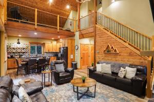 a living room with leather furniture and a staircase at Cottonwood Cabin in Glacier