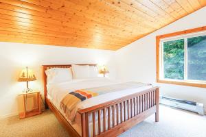 a bedroom with a bed with a wooden ceiling at Wandering Rivers Retreat in Glacier +48 photos