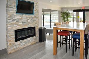 a living room with a fireplace and a table and chairs at Quality Inn Calhoun North I-75 in Calhoun