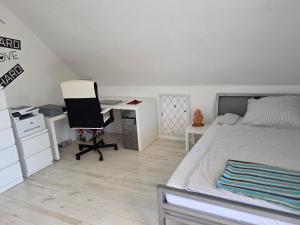 ein Schlafzimmer mit einem Bett und einem Schreibtisch mit Computer in der Unterkunft Studio Seeperle in Owingen