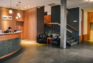 a woman sitting at a bar in a lobby with a laptop at Park Inn by Radisson Puerto Varas in Puerto Varas +78 photos