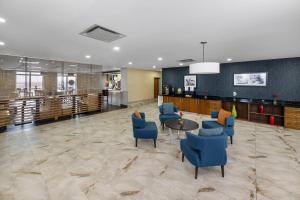 a lobby with blue chairs and a table at Radisson Hotel Edmonton Airport in Leduc