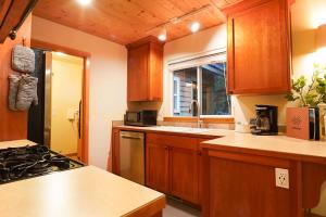 a kitchen with wooden cabinets and a stove top oven at Heliotrope Haus in Glacier