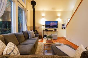 a living room with a couch and a tv at Heliotrope Haus in Glacier +32 photos