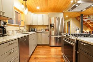a large kitchen with stainless steel appliances and wooden ceilings at Silver Peak Lodge in Glacier