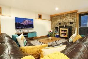 a living room with a leather couch and a fireplace at Silver Peak Lodge in Glacier