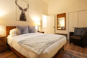 a bedroom with a large bed and a chair at Riversong Retreat in Glacier