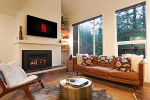 a living room with a couch and a fireplace at Riversong Retreat in Glacier