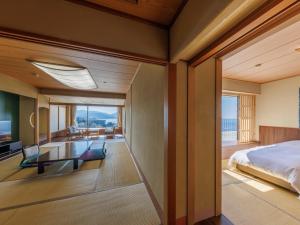 a bedroom with a bed and a view of the ocean at Dogashima New Ginsui in Nishiizu