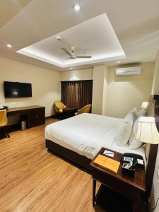 a hotel room with a bed and a desk and a television at Park Selections in Bhubaneshwar +20 photos