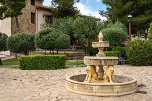 two dogs sitting in a fountain in a park at Hotel Balcón de los Montes in Colmenar